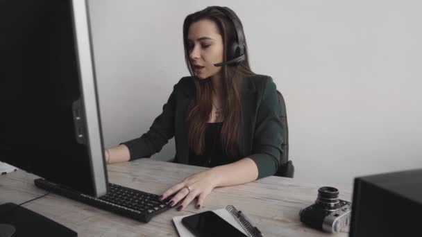 Jeune femme brune opérateur de service appelle au bureau. Jeune responsable du support client consultant le consommateur par casque répondant aux questions. Femme d'affaires souriante agent de soutien à la clientèle . — Video