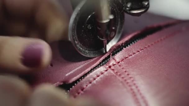 Machine à coudre dans un atelier de cuir en action avec des mains travaillant sur un détail en cuir pour chaussures. Macro shot de mains de femmes avec machine à coudre à l'usine de chaussures . — Video