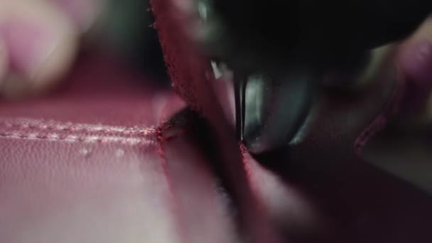 Machine à coudre dans un atelier de cuir en action avec des mains travaillant sur un détail en cuir pour chaussures. Macro shot de mains de femmes avec machine à coudre à l'usine de chaussures .
