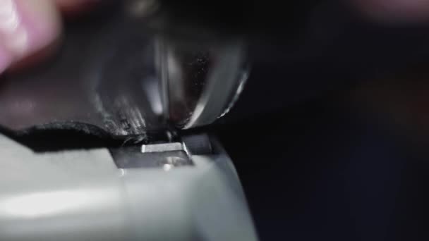 Machine à coudre dans un atelier de cuir en action avec des mains travaillant sur un détail en cuir pour chaussures. Macro shot de mains de femmes avec machine à coudre à l'usine de chaussures .