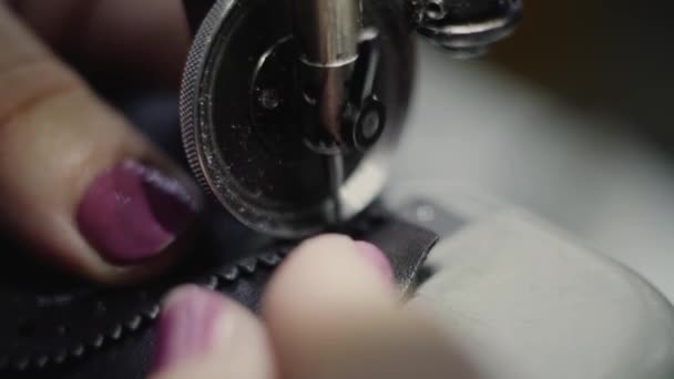Varrógép egy bőr műhelyben akció közben a kezét dolgozik egy bőr részleteket cipő. Makró lövés női kéz varrógép a cipőgyárban. — Stock videók