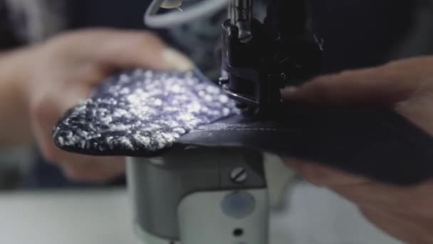 Machine à coudre dans un atelier de cuir en action avec des mains travaillant sur un détail en cuir pour chaussures. Macro shot de mains de femmes avec machine à coudre à l'usine de chaussures . — Video