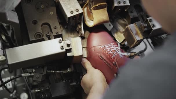 Człowiek użyć specjalnego narzędzia Maszyna do produkcji butów. Przenośnik taśmowy na fabrykę butów z buta i sole. Masowa produkcja obuwia. — Wideo stockowe