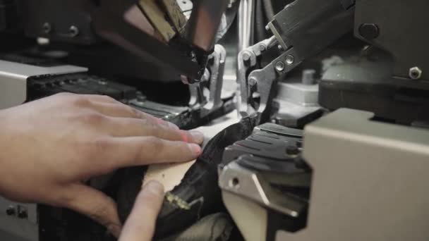 L'homme utilise une machine-outil spéciale pour fabriquer des chaussures. Le convoyeur sur une usine de chaussures avec chaussure et semelle. Production en série de chaussures . — Video