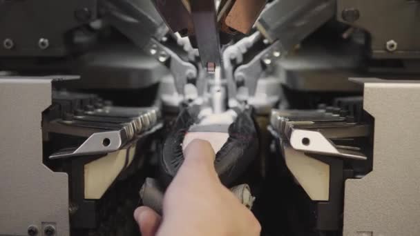 L'uomo usa macchine utensili speciali per fare le scarpe. Il trasportatore su una fabbrica di scarpe con scarpa e suola. Produzione di massa di calzature . — Video Stock