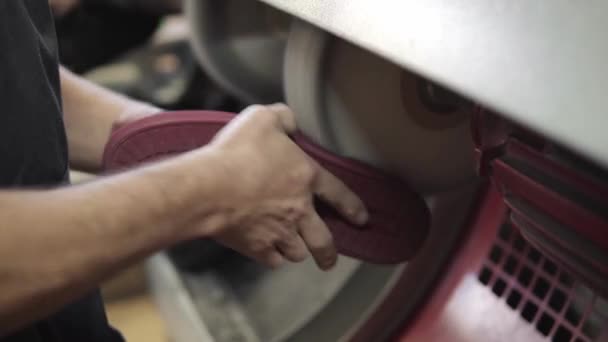 Полірування готового шкіряного взуття на взуттєвій фабриці. Чоловік працює на взуттєвій фабриці . — стокове відео