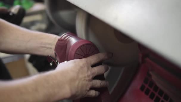 Polissage d'une chaussure en cuir fini sur une usine de chaussures. Homme travaillant sur une usine de chaussures .