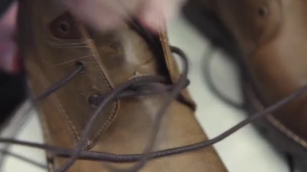 Lakování hotových kožených bot v továrně na boty. — Stock video