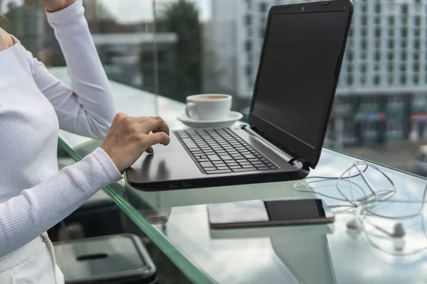 Una mujer está trabajando mediante el uso de una computadora portátil en la mesa. Manos escribiendo en un teclado. Mujer hombre de negocios está escribiendo en un teclado portátil sentado en la cafetería . — Foto de Stock