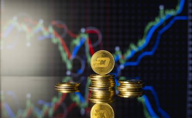 Bitcoinler ve sanal para konsepti. Şifreleme para biriminin büyüyen ve düşen değerinin grafiğiyle bir yığın madeni paranın üzerinde altın çizgi. Madencilik ya da engelleme teknolojisi.