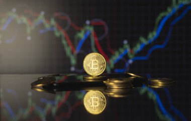 Bitcoinler ve sanal para konsepti. Şifreleme parasının büyüyen ve azalan değerinin grafiği olan madeni paraların üzerindeki altın bitsikkeler. Madencilik ya da engelleme teknolojisi.