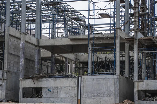 Construcción y construcción en curso. Edificio de construcción contra el cielo nublado. Construcción metálica del edificio sin terminar en la construcción del edificio de almacenamiento múltiple . — Foto de Stock