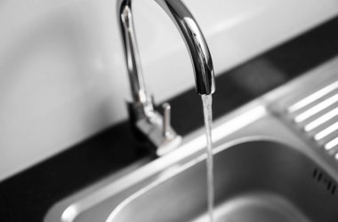 Modern mutfak metal musluğu ve metal mutfak lavabosu ile akan suyu kapatın..