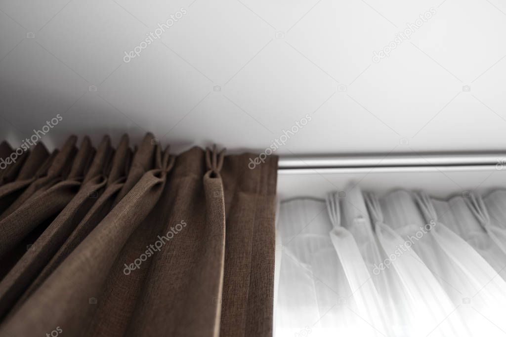 Brown curtains and white tulle on a rail with a white ceiling. Curtain interior decoration in living or sleeping room. Comfortable live in your own home. Sweet confy home.