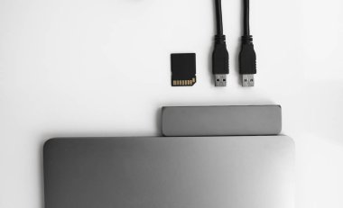 USB Tip-C adaptörlü USB kablosu ve SD kartı olan bir laptop. Laptop için C tipi konektörün altındaki USB adaptörü. Çok farklı portları olan bir bilgisayar için çok portlu istasyon. İnbot Dönüştürücü.