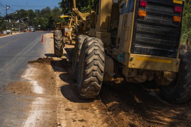 Grader yol inşaatında çalışıyor. Sınıf endüstriyel makine yeni yollar inşa ediyor. Otoyolda çalışan ağır iş makineleri. İnşaat malzemeleri. Yolun sıkıştırması.