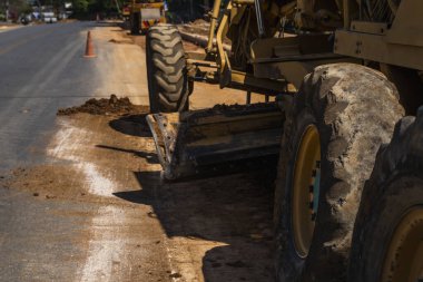 Yol inşaatında not verenlerin detayları üzerinde çalışıyor. Sınıf endüstriyel makine yeni yollar inşa ediyor. Otoyolda çalışan ağır iş makineleri. İnşaat malzemeleri. Yolun sıkıştırması.