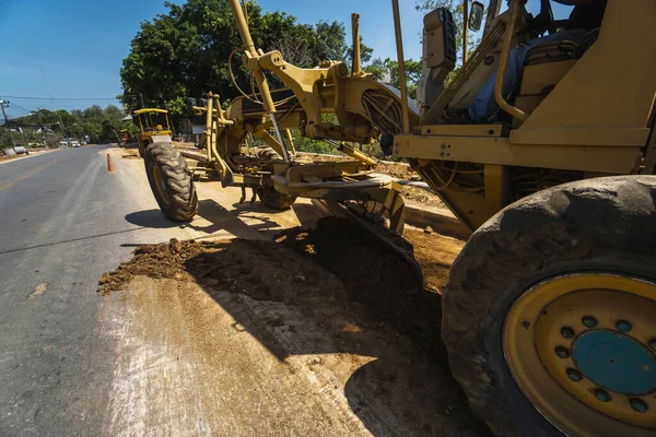 Yol inşaatında not verenlerin detayları üzerinde çalışıyor. Sınıf endüstriyel makine yeni yollar inşa ediyor. Otoyolda çalışan ağır iş makineleri. İnşaat malzemeleri. Yolun sıkıştırması.