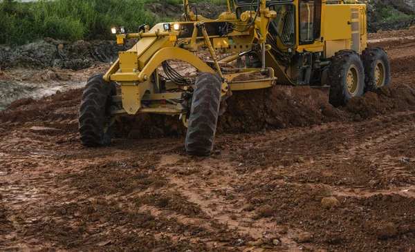 Grader is working on road construction. Grader industrial machine on construction of new roads. Heavy duty machinery working on highway. Construction equipment. Compaction of the road. — Stock Photo, Image