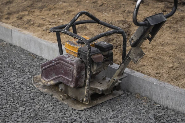 Wibracyjna nawierzchnia kamienna maszyna do wykończenia na placu budowy chodnika. — Zdjęcie stockowe