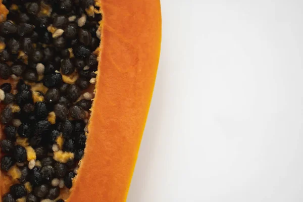 Half cut ripe papaya with seed on a white plate. Slices of sweet papaya with a white background. Halved papayas. Healthy exotic fruits. Vegetarian food. — Stock Photo, Image