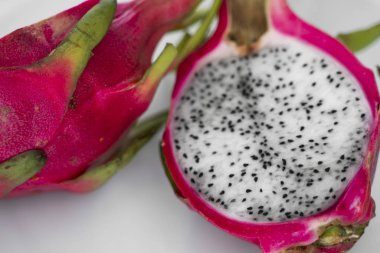 Ejderha meyvesi Beyaz arka planda canlı Ejderha Meyvesi. Dilimlenmiş beyaz ejderha meyvesi ya da masa üzerindeki beyaz tabakta pitaya, yakın plan. Tropikal ve egzotik meyveler. Sağlıklı ve vitaminli gıda kavramı.