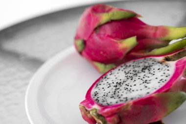 Ejderha meyvesi Beyaz arka planda canlı Ejderha Meyvesi. Dilimlenmiş beyaz ejderha meyvesi ya da masa üzerindeki beyaz tabakta pitaya, yakın plan. Tropikal ve egzotik meyveler. Sağlıklı ve vitaminli gıda kavramı.