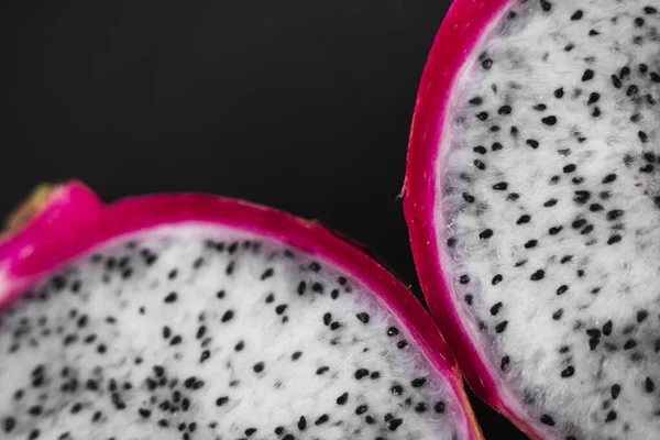 Drakenfruit. Levendig Dragon Fruit op zwarte achtergrond. Snijd wit drakenfruit of pitaya op zwarte plaat op tafel, close-up. Tropische en exotische vruchten. Gezonde en vitamine voedsel concept. — Stockfoto