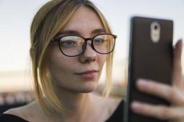 Genç iş kadını telefon kullanıyor. Güzel bir esmer kadın kredi kartından para aktarmak için internet bankacılığını akıllı telefonlarda kullanıyor. Akıllı telefon kullanan ve iş ortaklarıyla sohbet eden bir kız..