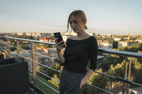 Jovem empresária usa telefone. Mulher morena bonita usa a banca on-line no telefone inteligente para transferir dinheiro do cartão de crédito. Menina usando telefone inteligente e conversando com parceiros de negócios . — Fotografia de Stock