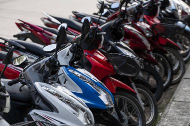 Krabi, Tayland - 10 Temmuz 2019. Krabi 'de motosikletlerle dolu her zamanki kalabalık park yeri. Turnuva alanında kaldırımda bir sürü motosiklet sıra sıra park ediyor..