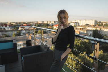 Genç bir iş kadını ofis binasının dışında akıllı cep telefonu kullanıyor ve iş ortaklarıyla konuşuyor. İş kadını telefona gülümseyerek cevap veriyor, iyi haberler alıyor. Serbest Çalışan.