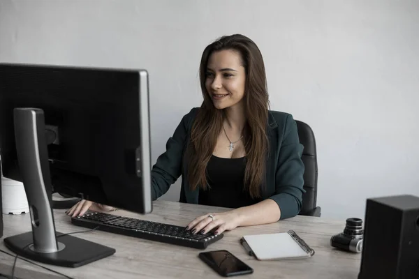 Brunetka pracuje przed monitorem w biurze. Bizneswoman pracująca przy komputerze w współpracowni kosmosu. Portret szczęśliwej damy piszącej w miejscu pracy. Kobieta zawodowo pracująca z komputerem PC. — Zdjęcie stockowe