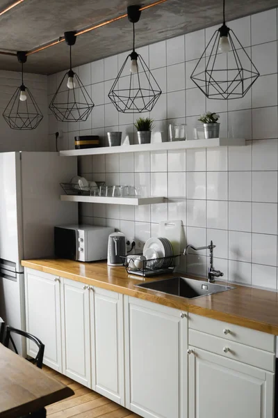 Modern, licht, schoon, keuken interieur met roestvrijstalen apparatuur in een luxe huis. Keuken in luxe herenhuis. Moderne architectuur eigentijds, interieur. Stijlvolle keukens interieur met tafel. — Stockfoto