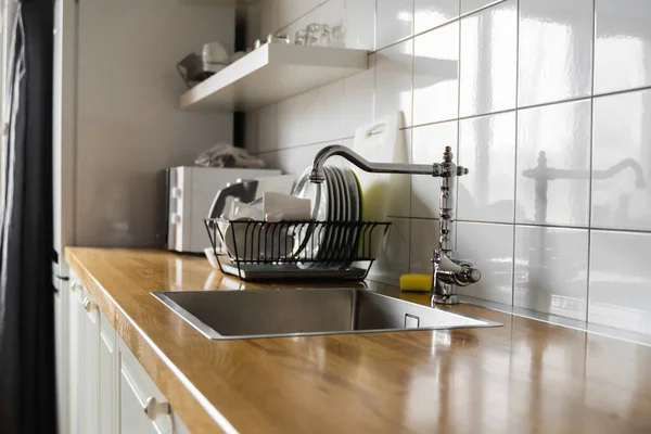 Wasbak en kraan. Roestvrij aanrecht en kraanwater. Het interieur van de moderne keuken kamer in het loft appartement. Ingebouwde apparaten en toestellen. — Stockfoto