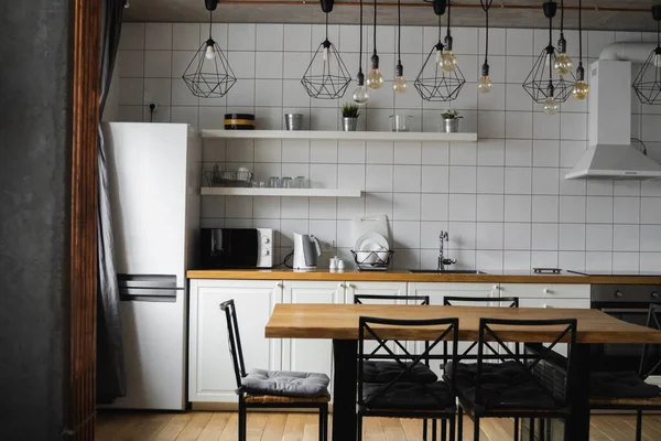 Μοντέρνο, φωτεινό, καθαρό, εσωτερικό κουζίνας με ανοξείδωτες συσκευές σε πολυτελές σπίτι. Κουζίνα σε πολυτελές αρχοντικό. Σύγχρονη αρχιτεκτονική σύγχρονη, εσωτερικό. Κομψό εσωτερικό κουζίνες με τραπέζι. — Φωτογραφία Αρχείου