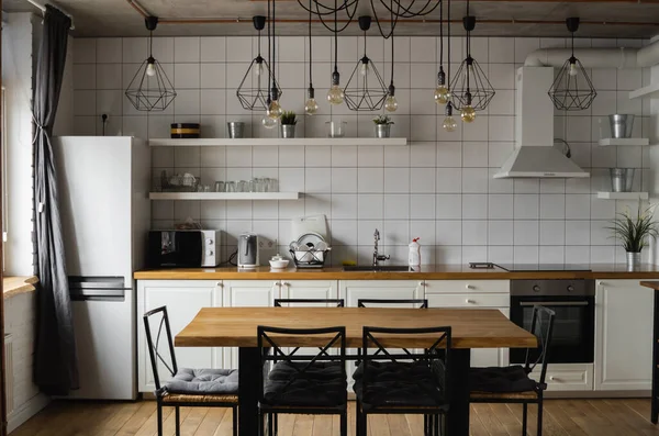 Modern, licht, schoon, keuken interieur met roestvrijstalen apparatuur in een luxe huis. Keuken in luxe herenhuis. Moderne architectuur eigentijds, interieur. Stijlvolle keukens interieur met tafel. — Stockfoto