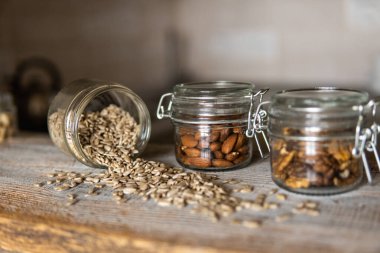 Beyaz şarap masasına serpiştirilmiş ayçiçeği tohumları kavanozda diğer fındıklar ile birlikte. Sağlıklı vejetaryen protein besleyici gıdalar. Kırsal kesimde ayçiçeği tohumu.