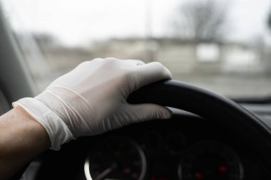 Kendini bakterilerden ve virüsten korumak için koruyucu maske takan adam araba kullanmayı planlıyor. Salgın sırasında koruyucu maske, karantina, dünya salgını, covid 19, koronavirüs, enfeksiyon.