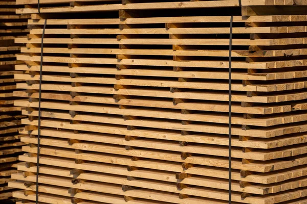Warehouse for sawing boards on a sawmill outdoors. Timber mill, sawmill. Storage of planed wooden boards. Piles of wooden boards in the sawmill. Planking. Industry. — Stock Image Warehouse for sawing boards on a sawmill outdoors. Timber mill, sawmill. Storage of planed wooden boards. Piles of wooden boards in the sawmill. Planking. Industry. Stock Image