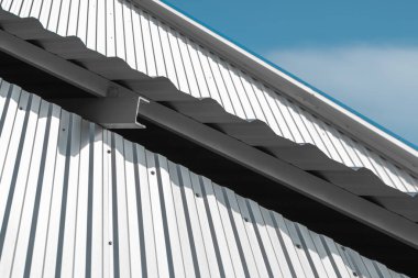 Duvarın beyaz metal kaplama yüzeyi ve çatının metal köşesi. Galvanize çelik arkaplan.