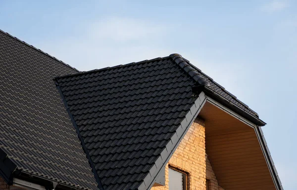 Takpannor i brun metall. Takplåt. Moderna typer av takmaterial. Taket på huset, metalltakpanna mot den blå himlen. Byggnad. — Stockfoto