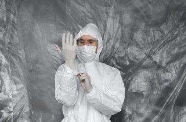 Beyaz koruyucu giysili, maskeli, gözlüklü ve lastik eldivenli doktor koronavirüs salgını tehdidi altındaki insanlara yardım etmeye hazır. Salgın, Coronavirus covid 19 salgını. Solunum cihazındaki doktor..
