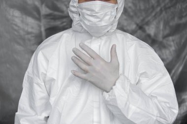 Beyaz koruyucu giysili, maskeli, gözlüklü ve lastik eldivenli doktor koronavirüs salgını tehdidi altındaki insanlara yardım etmeye hazır. Salgın, Coronavirus covid 19 salgını. Solunum cihazındaki doktor..