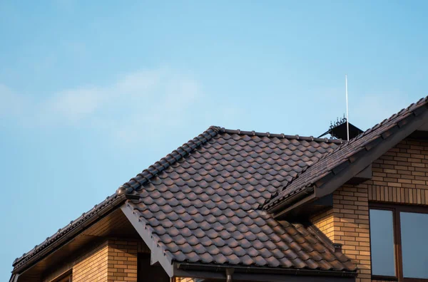 Bruin natuurlijk tegeldak. Moderne soorten dakbedekking. Dak van het huis, Natuurlijke dakpan tegen de blauwe lucht. Gebouw. — Stockfoto