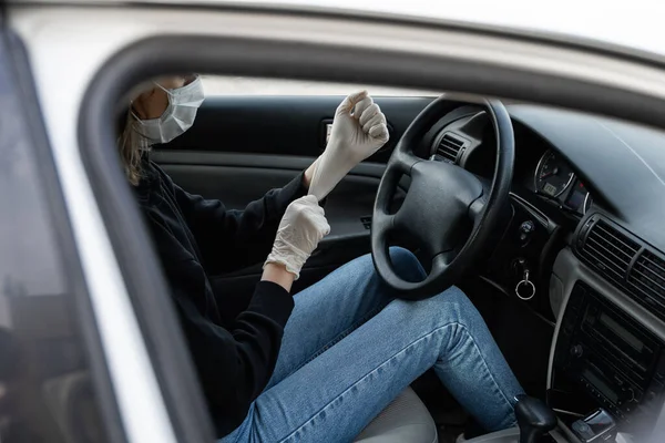 防護医療用マスクの女性は、運転を計画している間、細菌ウイルスから身を守るためにゴム手袋を着用しています。隔離中の保護マスク、パンデミック、 covid 19 、コロナウイルス、感染. — ストック写真