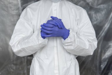 Beyaz koruyucu giysili, maskeli, gözlüklü ve lastik eldivenli doktor koronavirüs salgını tehdidi altındaki insanlara yardım etmeye hazır. Salgın, Coronavirus covid 19 salgını. Solunum cihazındaki doktor..