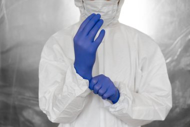 Beyaz koruyucu giysili, maskeli, gözlüklü ve lastik eldivenli doktor koronavirüs salgını tehdidi altındaki insanlara yardım etmeye hazır. Salgın, Coronavirus covid 19 salgını. Solunum cihazındaki doktor..