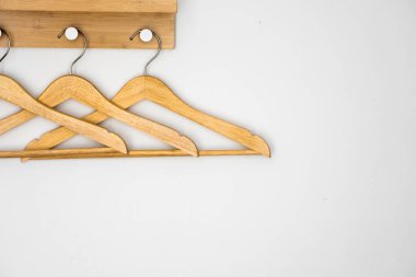 Beyaz duvarda ahşap askılar var..