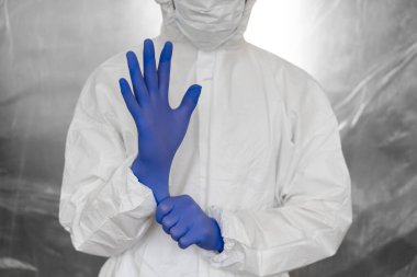 Beyaz koruyucu giysili, maskeli, gözlüklü ve lastik eldivenli doktor koronavirüs salgını tehdidi altındaki insanlara yardım etmeye hazır. Salgın, Coronavirus covid 19 salgını. Solunum cihazındaki doktor..
